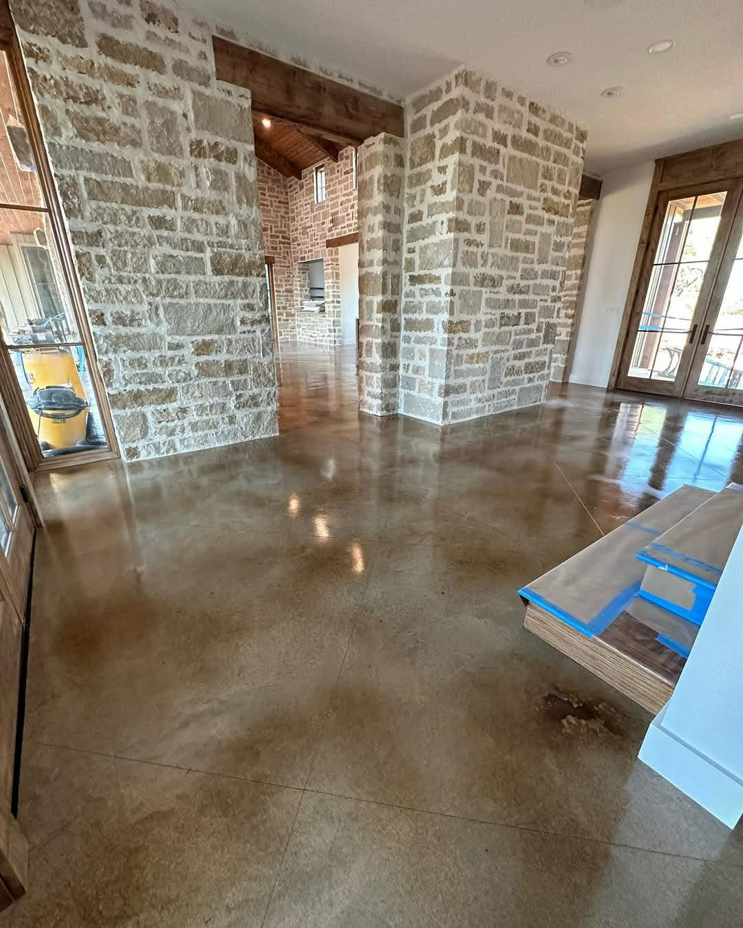 Interior stained concrete floor with stone walls and a high-gloss finish